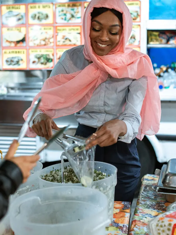 A woman serving food at her market stall